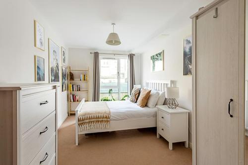 um quarto com uma cama branca e uma janela em Cosy Apartment In Vibrant Whitechapel em Londres
