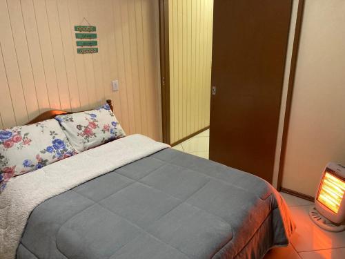 a bedroom with a bed with a pillow and a lamp at Apartamento para casal in Cambara do Sul