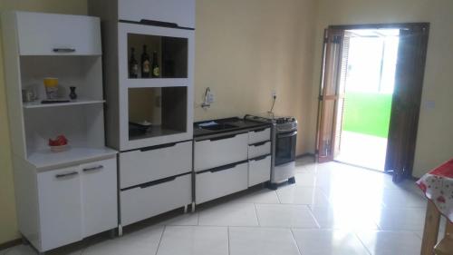 a kitchen with white cabinets and a stove at Apartamento para casal in Cambara do Sul