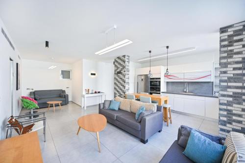 ein Wohnzimmer mit einem Sofa und einem Tisch in der Unterkunft Vernal By HolyGuest in Tel Aviv