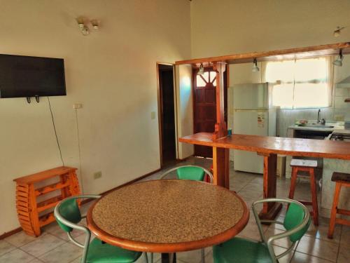 a room with a table and chairs and a kitchen at Alojamiento Casa en El Bolsón in El Bolsón