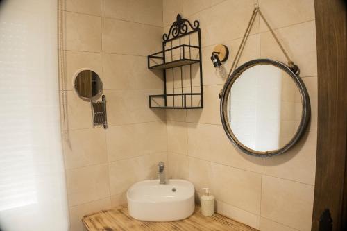 a bathroom with a sink and a mirror at CASA RURAL VEGASAN in Santa Colomba de la Vega