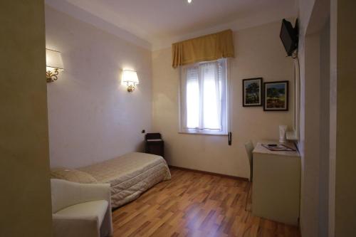Habitación pequeña con cama y ventana en Hotel Vienna Ostenda e Ristorante il Danubio, en Rímini