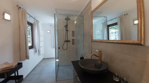 La salle de bains est pourvue d'un lavabo et d'une douche avec un miroir. dans l'établissement Ferienhaus SCHWEIZER Hof, à Tamsweg