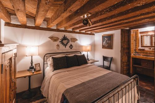 a bedroom with a bed and a desk with two lamps at El Edén Hotel Boutique in Pátzcuaro