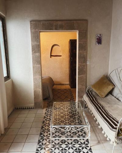 a room with a hallway with a bed and a table at Dar Halima in Essaouira