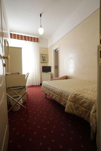 a hotel room with a bed and a desk at Hotel Vienna Ostenda e Ristorante il Danubio in Rimini