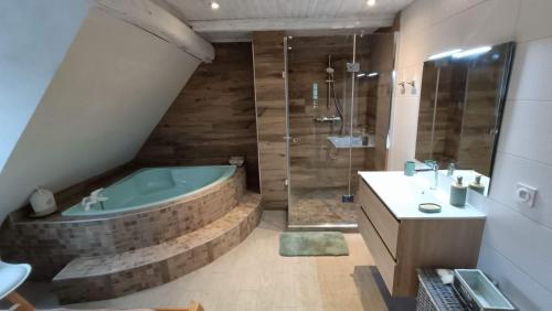 a bathroom with a tub and a sink at Un balcon sur les toits in Beblenheim