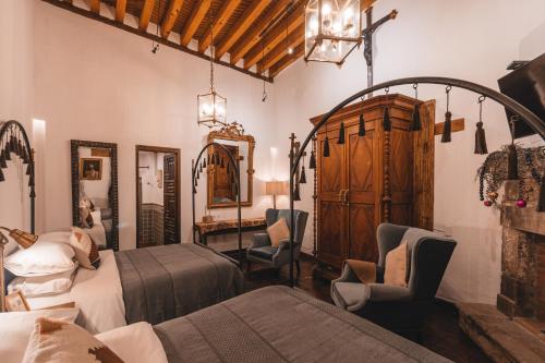 a bedroom with two beds and a table and chairs at El Edén Hotel Boutique in Pátzcuaro