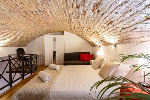 a bedroom with a large bed with a brick ceiling at Modern stylish apartment @ Superb central location in Budapest