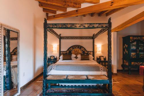 an antique bed in a bedroom with a wooden ceiling at El Edén Hotel Boutique in Pátzcuaro
