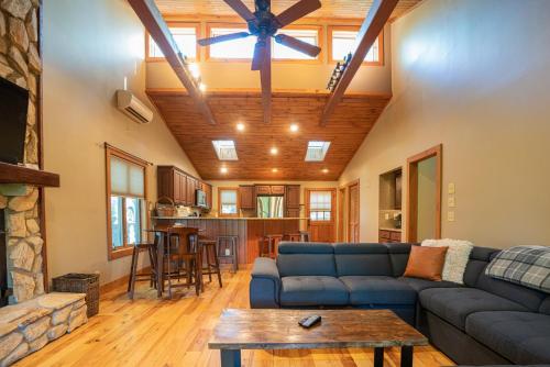 a living room with a blue couch and a ceiling fan at King Bed, Putt-Putt w/ Hot Tub, & Other Games in Banner Elk