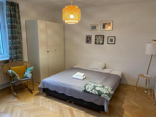 sypialnia z łóżkiem, krzesłem i lampką w obiekcie Slow Life Apartment next to Metro Station w Warszawie