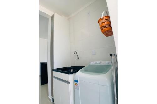 Una pequeña cocina con lavadora y secadora. en Maravilhoso apartamento 100m Mar - MB04G, en Florianópolis