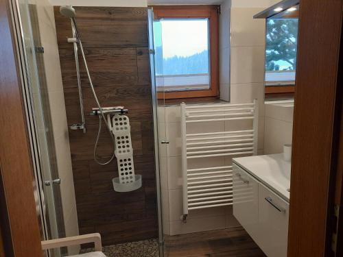 baño con ducha y puerta de madera en Ferienwohnungen Wimmer en Bischofshofen