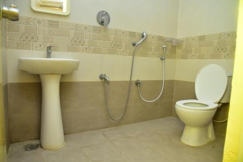 a bathroom with a sink and a toilet and a shower at SAI SADHAN RESIDENCY in Chittoor
