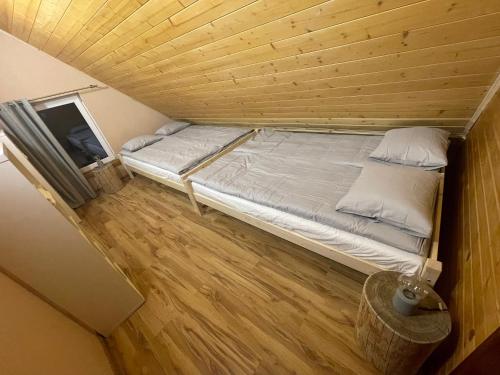 a bed in a room with a wooden ceiling at Dom Pod Świerkami in Istebna