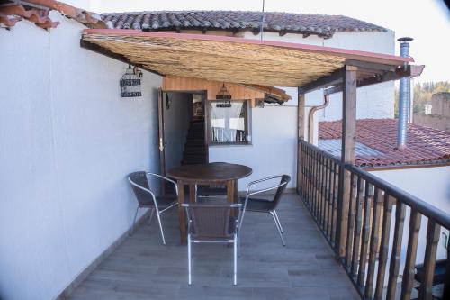 a patio with a table and chairs on a balcony at CASA RURAL VEGASAN in Santa Colomba de la Vega