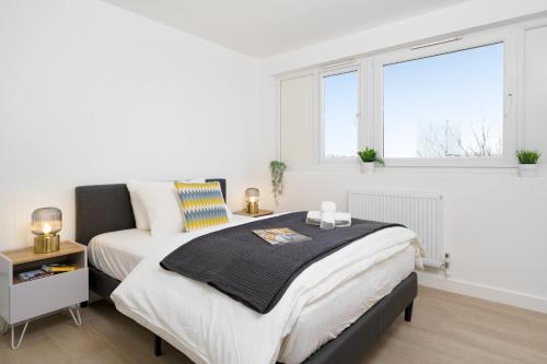 um quarto com uma cama e duas janelas em Stunning Duplex near Canary Wharf & O2 & City Views em Londres