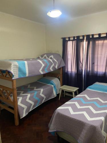 1 dormitorio con 2 camas individuales y ventana en Departamento Av. España en Mendoza
