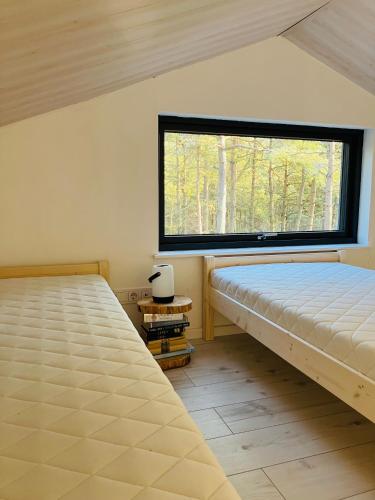 2 camas en una habitación con ventana en Forest House, Tiidu, en Nässuma