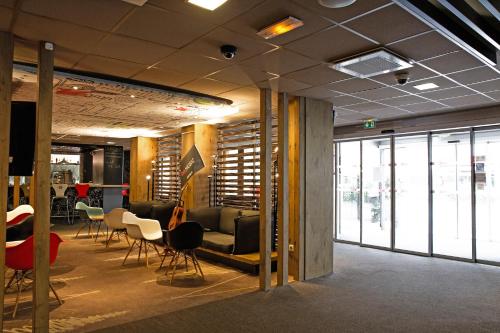 a conference room with chairs and tables and windows at ibis Paris Porte D'Orleans in Montrouge
