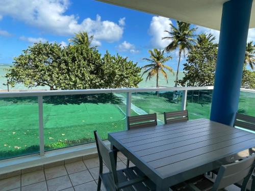 a table and chairs on a balcony with a view of the ocean at Costa Mar Beach Front Apartment Whith Pool in Loiza