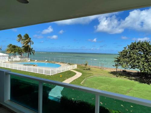 a view of the ocean from the balcony of a house at Costa Mar Beach Front Apartment Whith Pool in Loiza