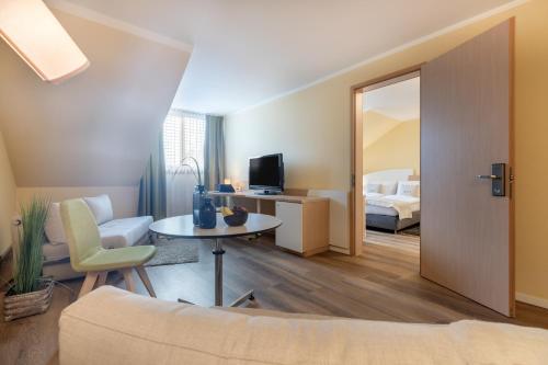 ein Wohnzimmer mit Sofa und ein Schlafzimmer in der Unterkunft Select Hotel Erlangen in Erlangen