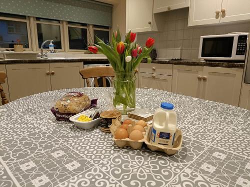 a table with a vase of flowers and eggs on it at Pandy Barn Berriew in Welshpool