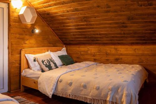 sypialnia z łóżkiem w drewnianym domku w obiekcie Biniște -Tiny House by the river w mieście Dejani
