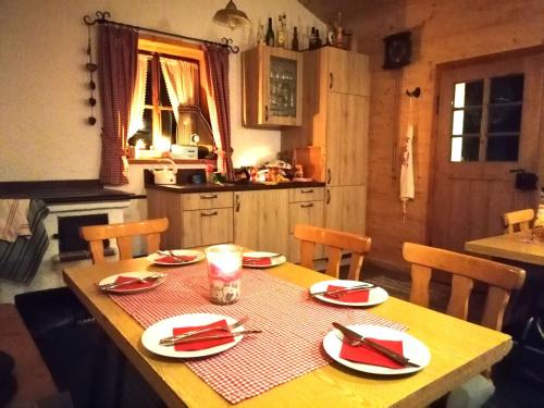 a wooden table with red napkins on it in a kitchen at Matheishof inkl. Chiemgaukarte in Ruhpolding