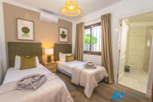 pokój hotelowy z dwoma łóżkami i łazienką w obiekcie 222 - Villa Noches De Luna by Villas Now Ltd w mieście Playa Blanca