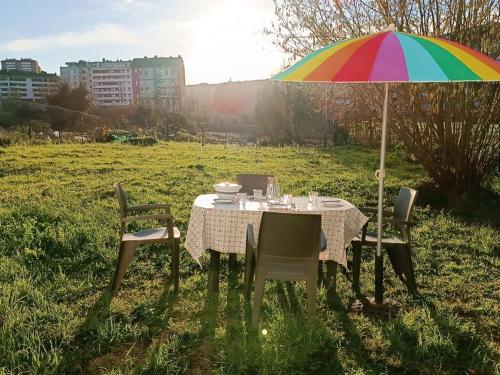 a table with a multicolored umbrella in a field at Casa Oviedo centro in Oviedo