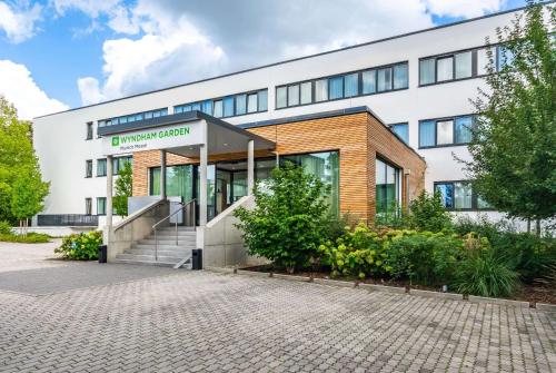 un edificio de oficinas con una escalera delante de él en Wyndham Garden Munich Messe en Múnich