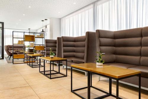 a waiting room with couches and tables at Wyndham Garden Munich Messe in Munich