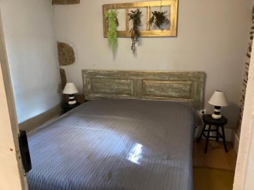 a bedroom with a bed with two lamps and two pictures on the wall at Casadaldeiadalmofala in Almofala