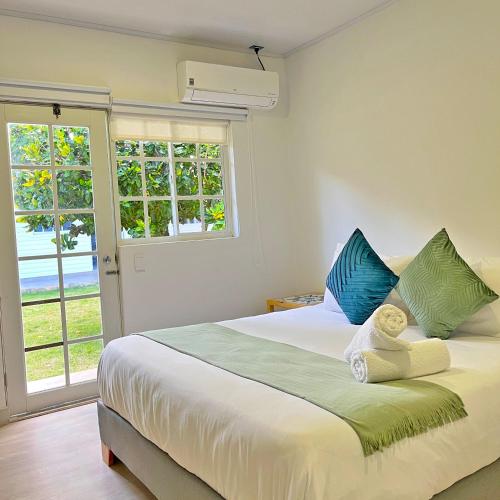 a bedroom with a large bed with blue and green pillows at Zaba Beach House in San Andrés