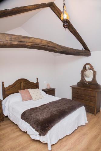 a bedroom with a large bed with a brown blanket at CASA RURAL VEGASAN in Santa Colomba de la Vega