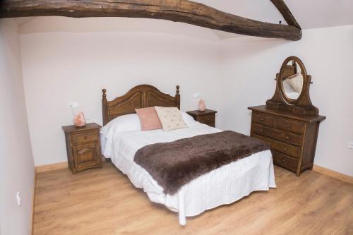 a bedroom with a bed and two dressers and a mirror at CASA RURAL VEGASAN in Santa Colomba de la Vega