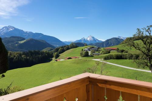a balcony with a view of a green field and mountains at Ferienwohnung Grasmannlehen in Marktschellenberg