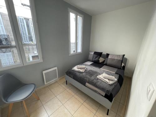 une chambre avec un lit, une chaise et des fenêtres dans l'établissement Marseille : Appartement T2 avec terrasse, à Marseille
