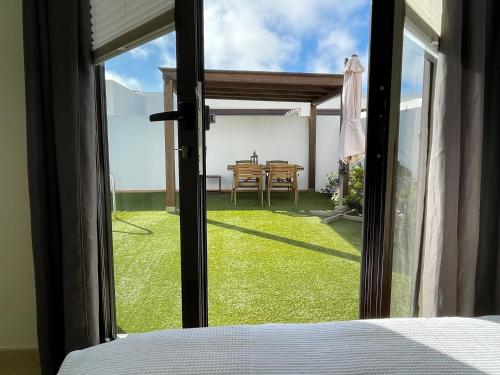 een slaapkamer met een raam met uitzicht op een tuin bij Casa Sol y Mar Azul un'oasi a due passi dal mare in Playa Blanca