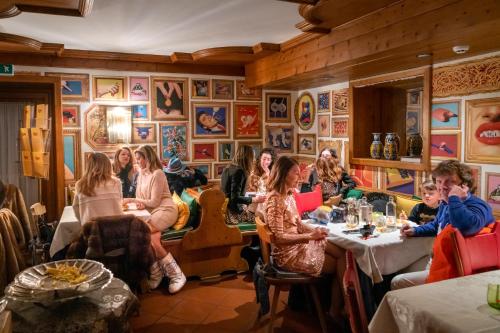 um grupo de pessoas sentadas às mesas de um restaurante em Ambra Cortina Luxury&Fashion Hotel em Cortina dʼAmpezzo