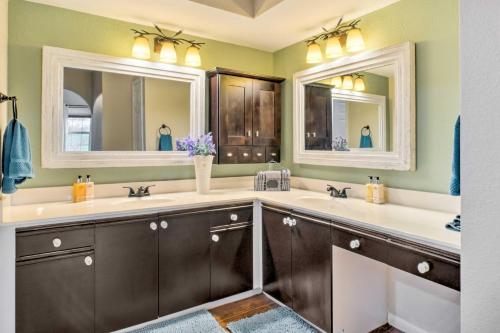 a bathroom with two sinks and two mirrors at Holiday Hills Resort Condo Mins to Branson Strip! in Branson