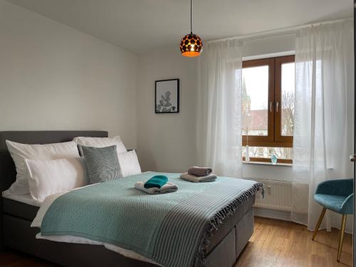 雷寧根的住宿－Apartment Modern Stylish-kitchen,BLK near Fair-Bosch Forschung-Zentrum，一间卧室配有一张床,上面有两条毛巾