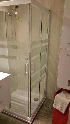 La salle de bains est pourvue d'une douche avec des portes en verre. dans l'établissement Studio double cabine vu mer, au Grau-du-Roi