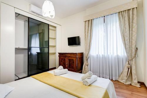 a bedroom with a large window and a bed with towels at Exclusive Apartment in Eur Lake in Rome