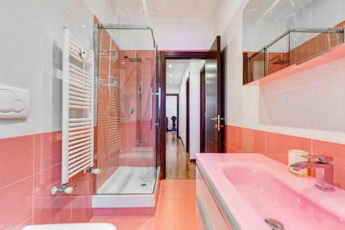a pink bathroom with a shower and a sink at Exclusive Apartment in Eur Lake in Rome
