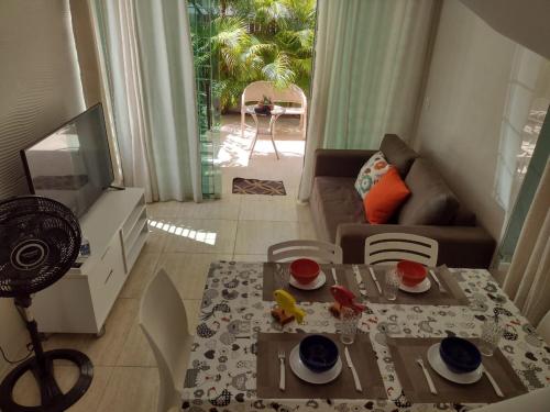 a living room with a table and a couch and a television at Flat Beach Selma in Porto De Galinhas